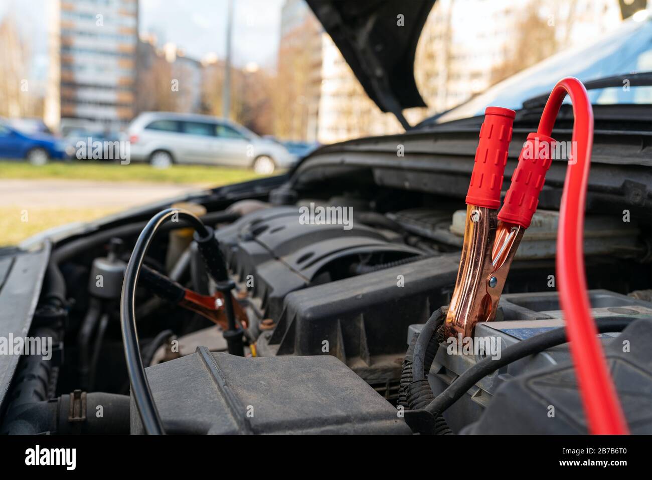 Kabel an der Batterie mit geringer Batterieleistung im Auto springen. Startversuch eines defekten Autos. Selektiver Fokus. Stockfoto
