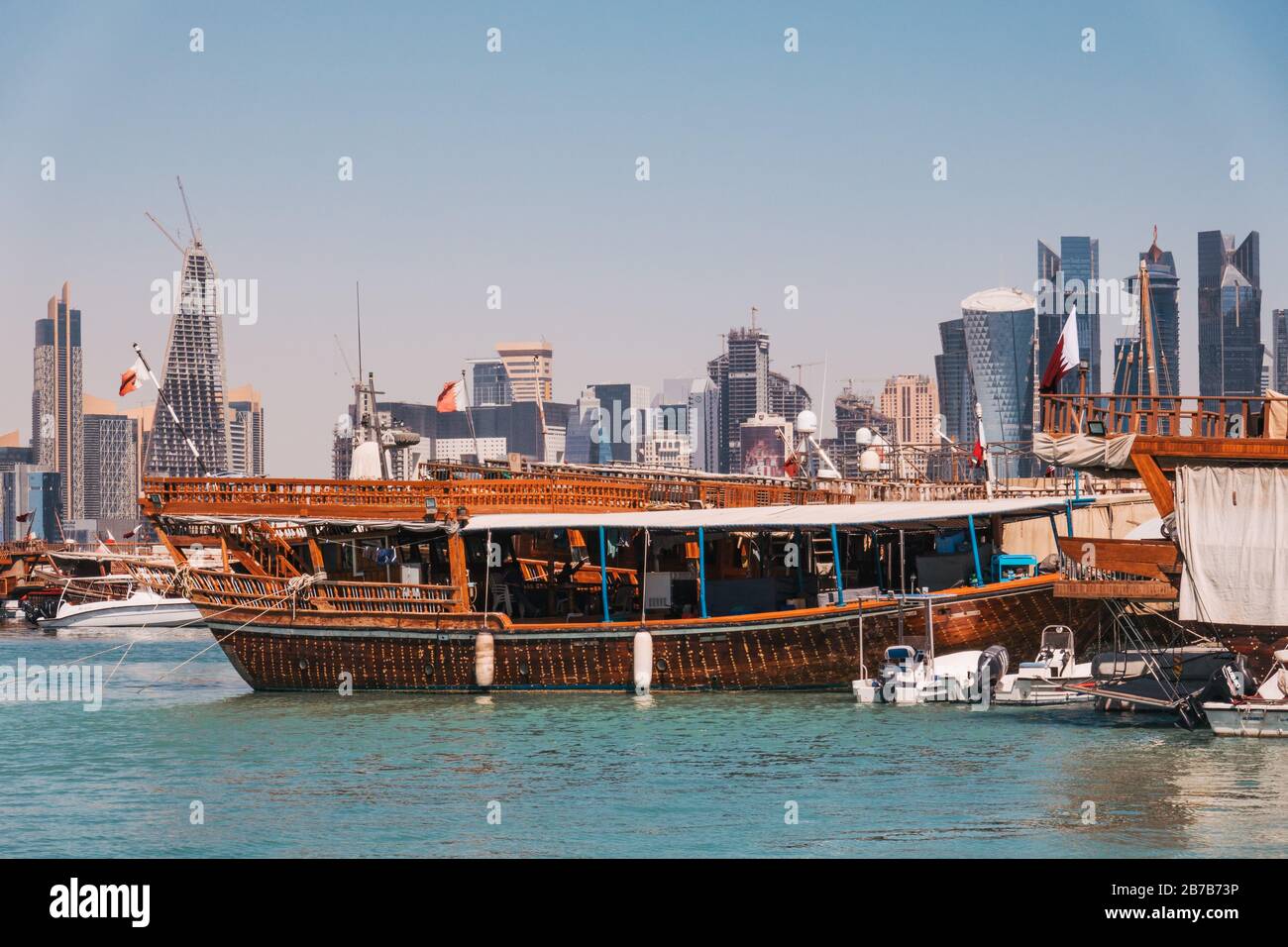 Dhow Boote geparkt am Dhow Hafen mit der finanziellen Zentrum Skyline sichtbar hinter, ein Sommermorgen in Doha, Katar Stockfoto