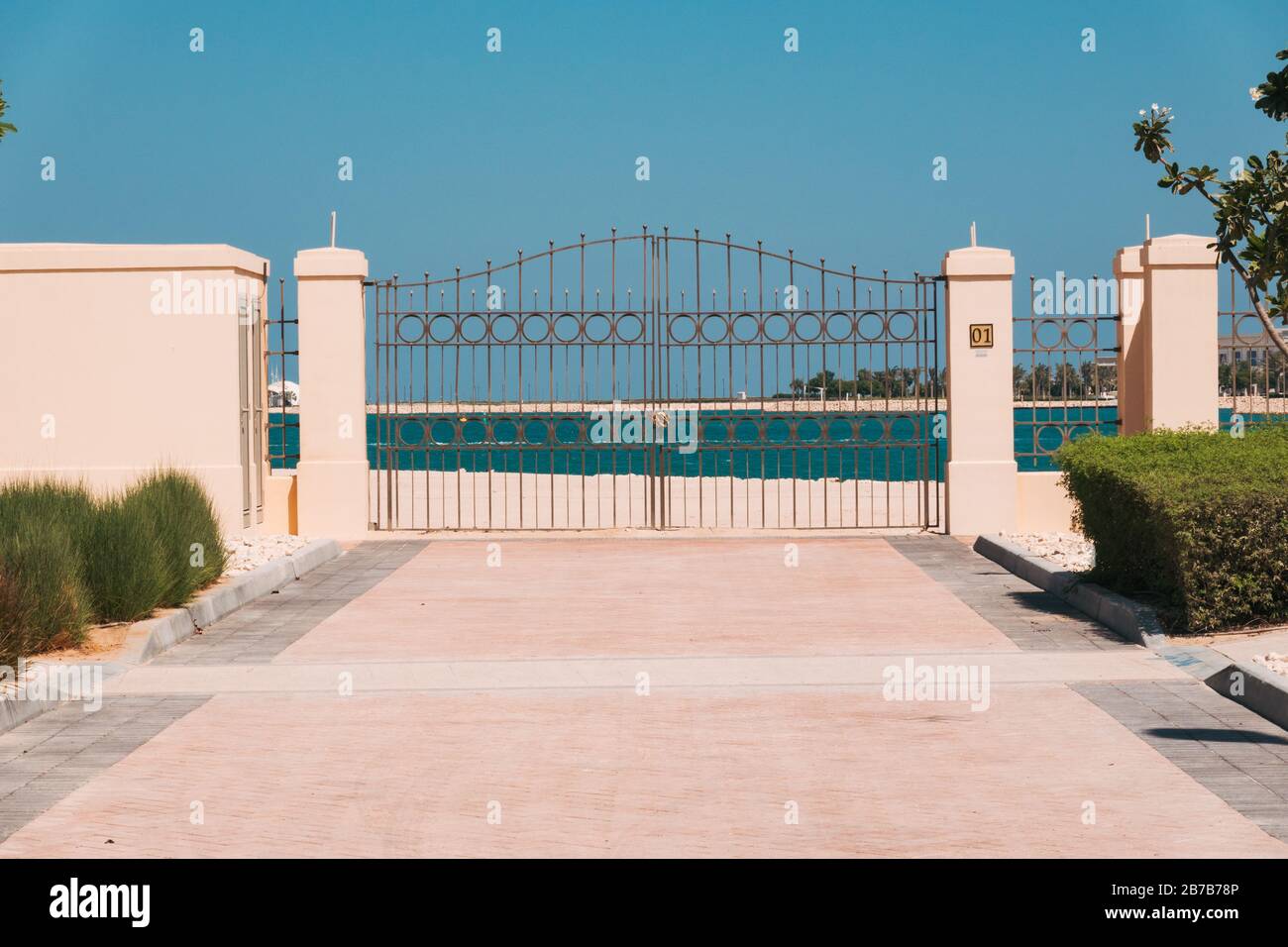 Eine Auffahrt und Tor mit nichts dahinter auf einer Immobilienentwicklung auf der Pearl, einem exklusiven Wohngebiet in Doha, Katar Stockfoto