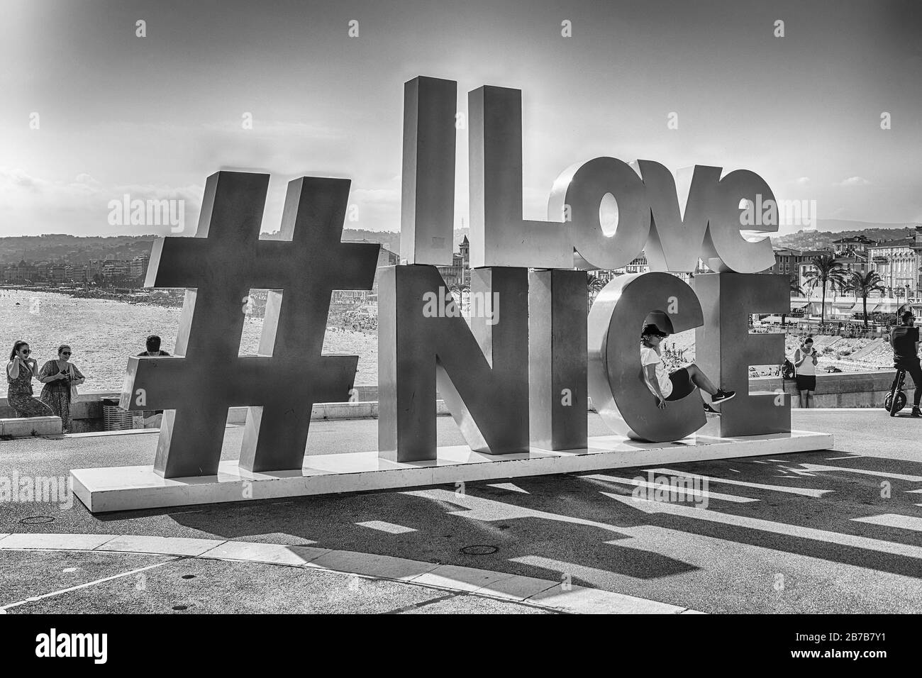 NIZZA, FRANKREICH - 11. AUGUST: Touristen, die Fotos am Schild "I Love Nice" machen, mit Blick auf die Küste und die Promenade des Anglais auf dem Hintergrund Stockfoto