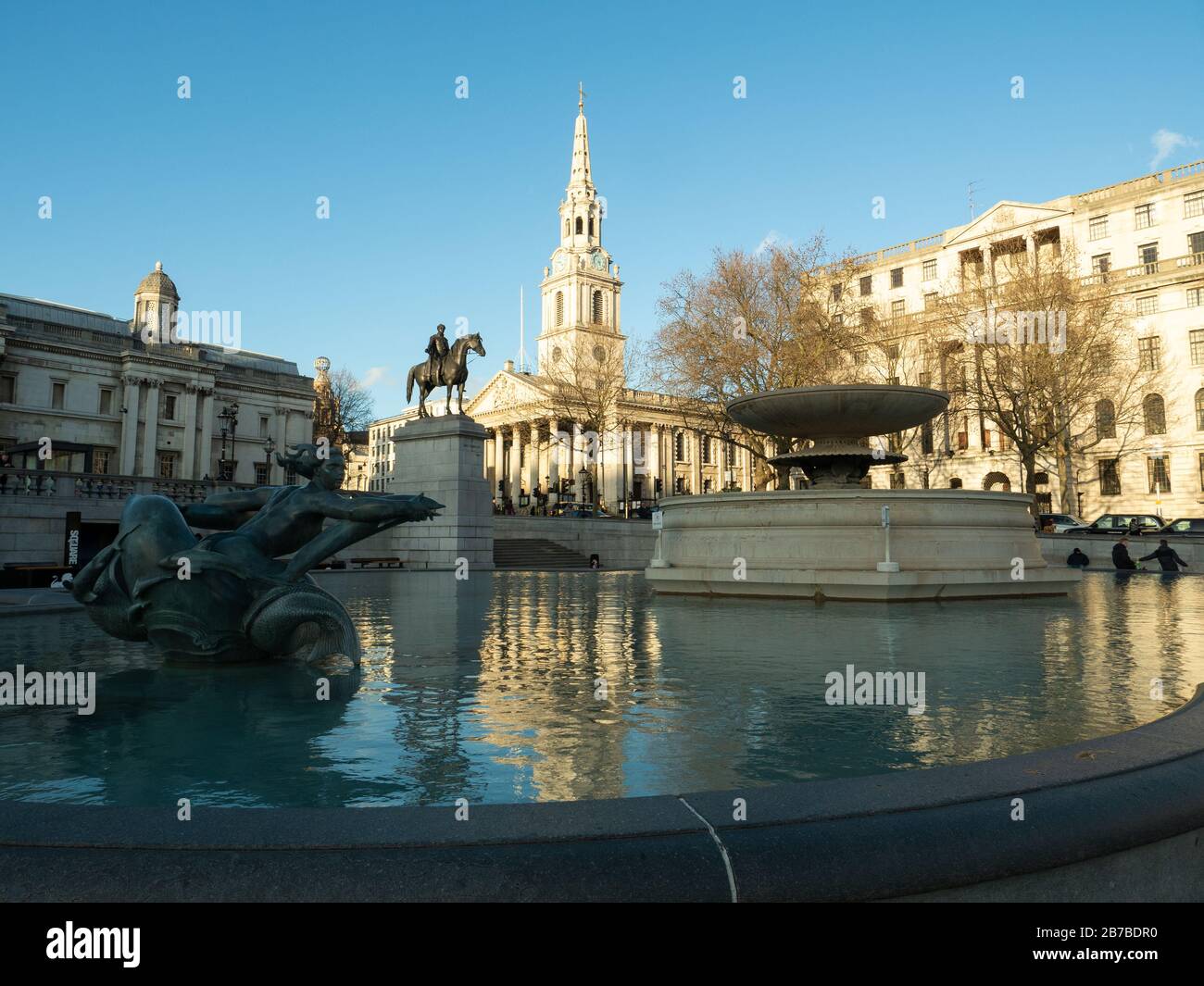 Trafalgar-Platz mit einem Brunnen im Vordergrund und St. Martin in der Field-Kirche dahinter Stockfoto