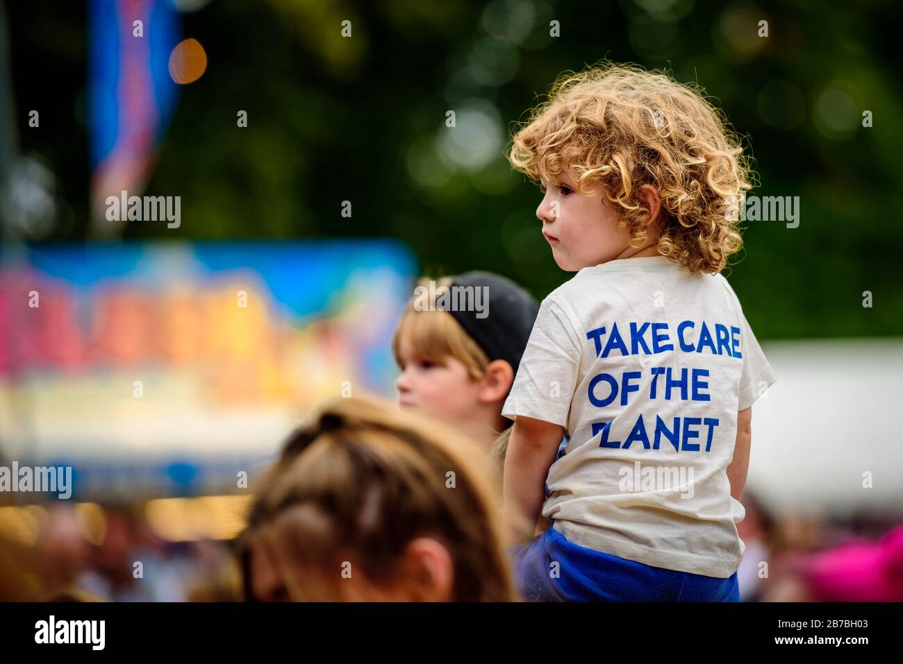 Ein Kind sitzt auf den Schultern seiner Eltern bei einem Musikfestival Stockfoto