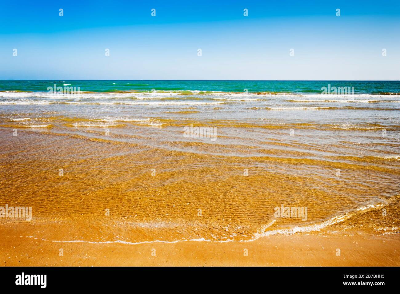 Sauberes Wasser, sandiger Strand, Sommerhintergrund. Sommerliche Ozeankulisse Stockfoto