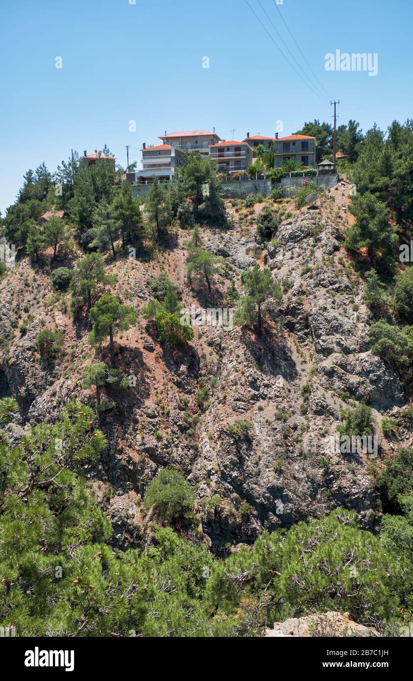 Die Häuser auf dem Felsen über den Naturpfad entlang des Kryos-Flusstals bis zum Millomeris Wasserfall. Platres, Zypern. Stockfoto