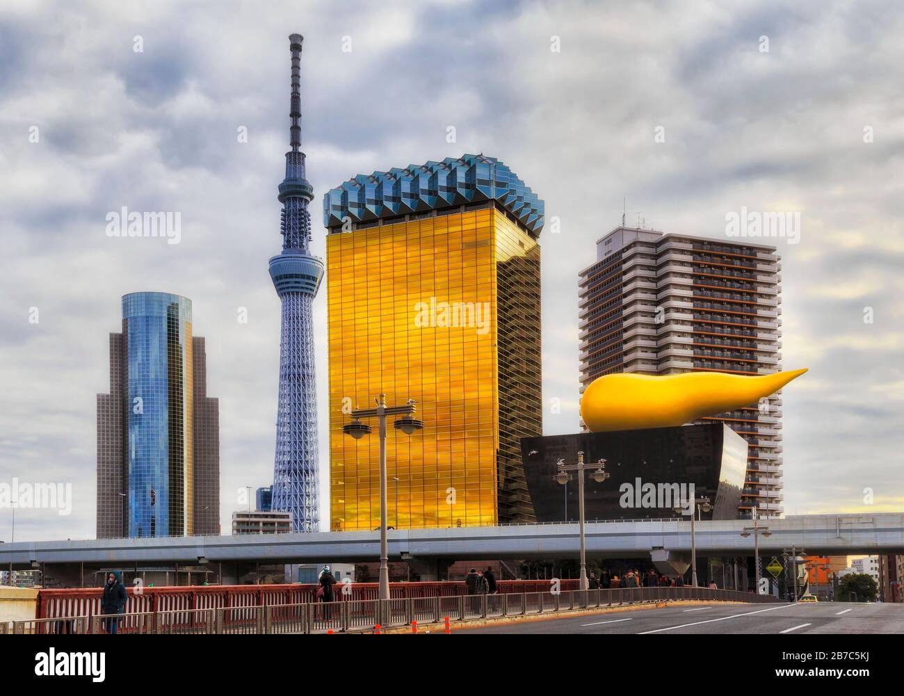 Hoher runder fernseh- und Radioturm in der japanischen Stadt Tokio, Himmelsbaum und Straßenlampen entlang der Brücke. Stockfoto