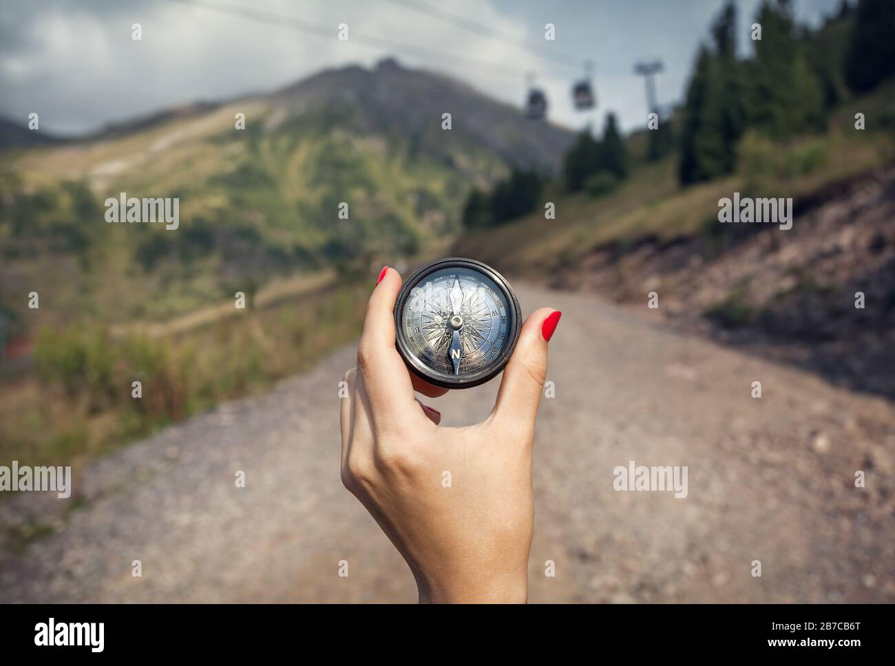 Hand der Frau Tourist mit Vintage-Kompass an der Bergstraße Stockfoto