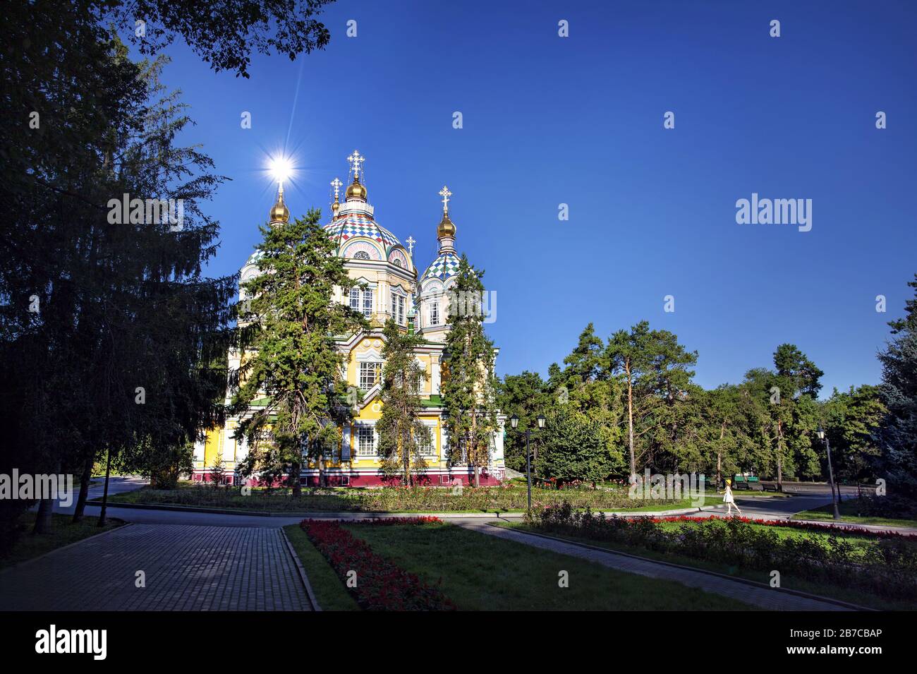 Frau in weißem Kleid und Gelb in die berühmte orthodoxe Kirche in Almaty, Kasachstan Stockfoto