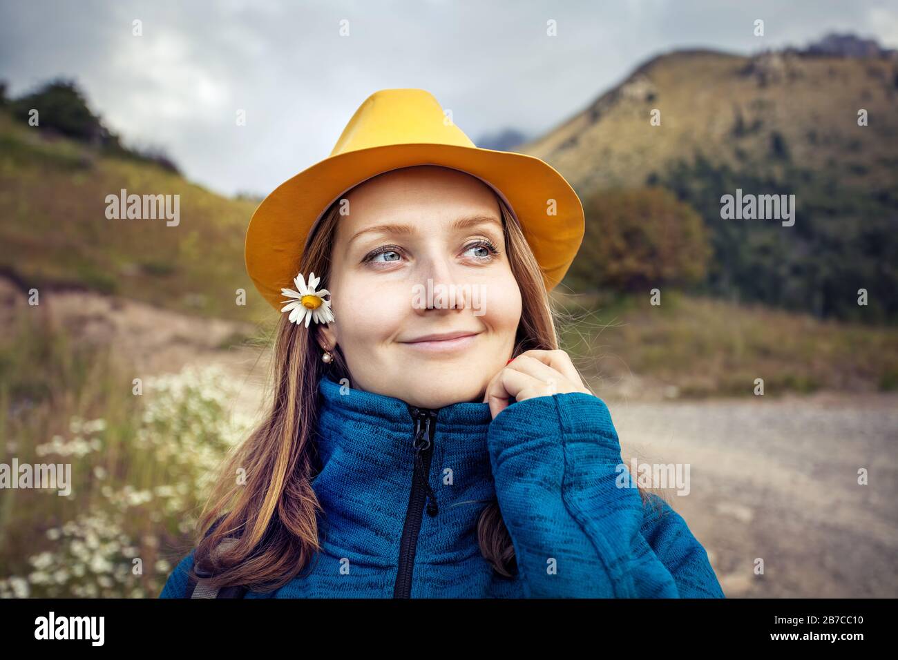 Junge und glückliche Frau Touristin im gelben Hutporträt auf Bergen in Kasachstan Stockfoto