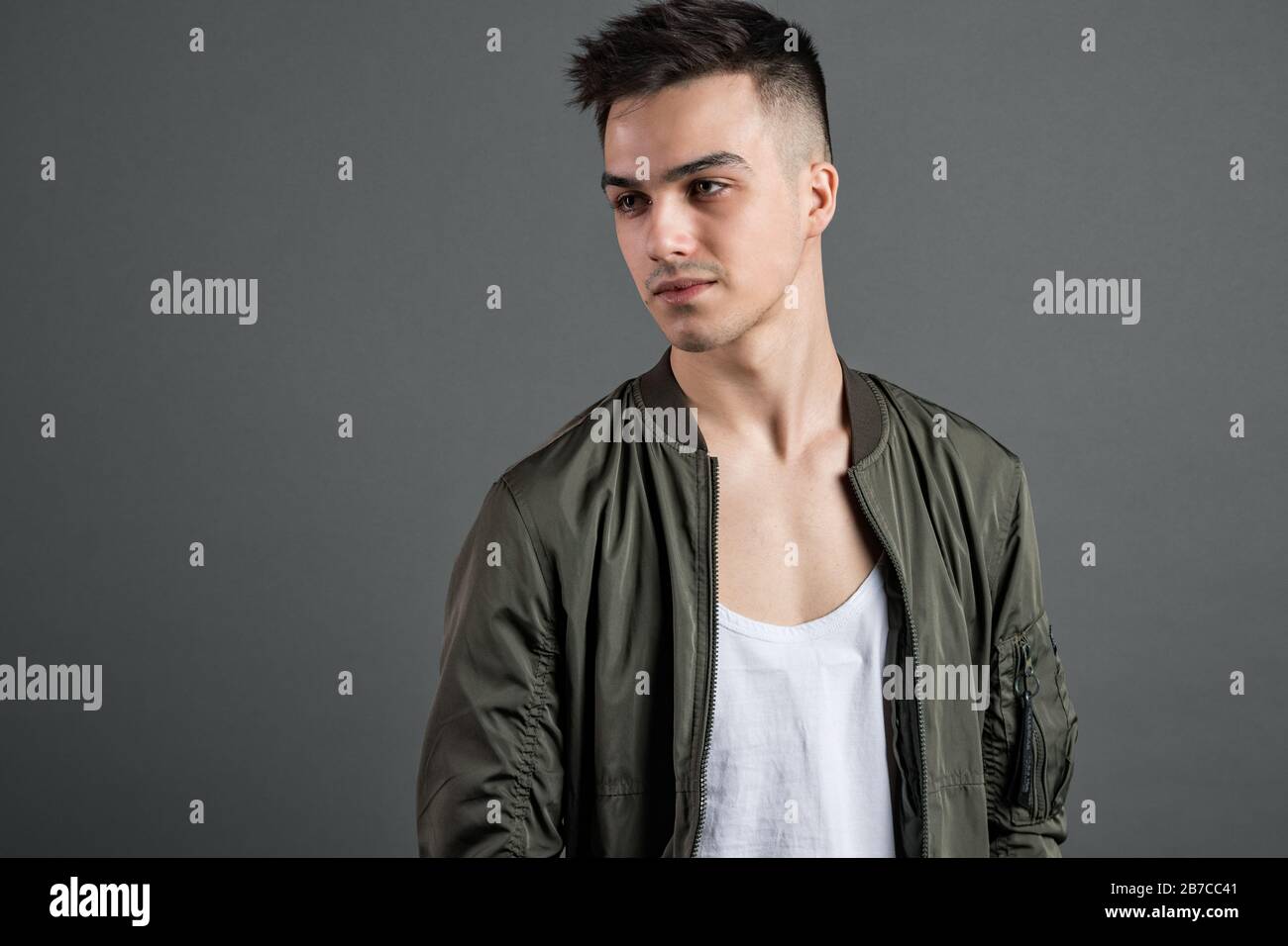 Junger seriöser Mann, der im Studio posiert Stockfoto