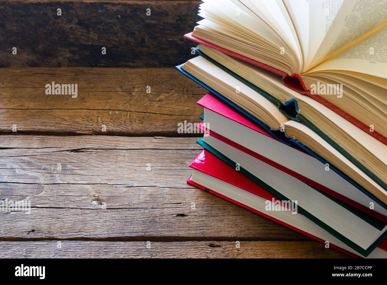 Öffnen Sie das Buch auf einem Stapel geschlossener Bücher mit Platz für Text Stockfoto