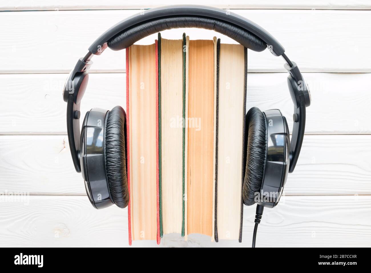 Kopfhörer mit Vintage-Büchern auf weißem Hintergrund Stockfoto
