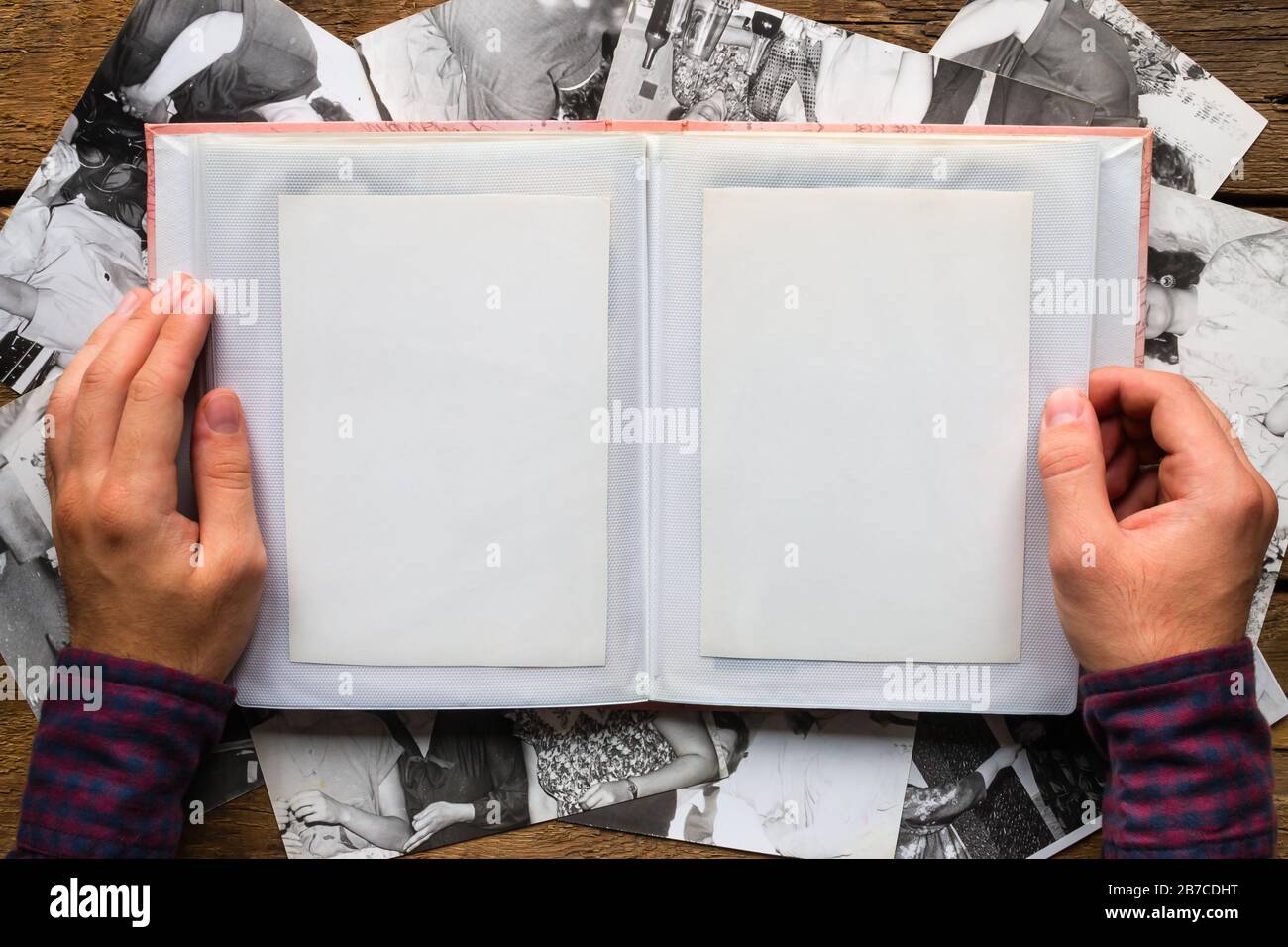 Mann, der Fotos auf dem Hintergrund alter Fotos sieht Stockfoto