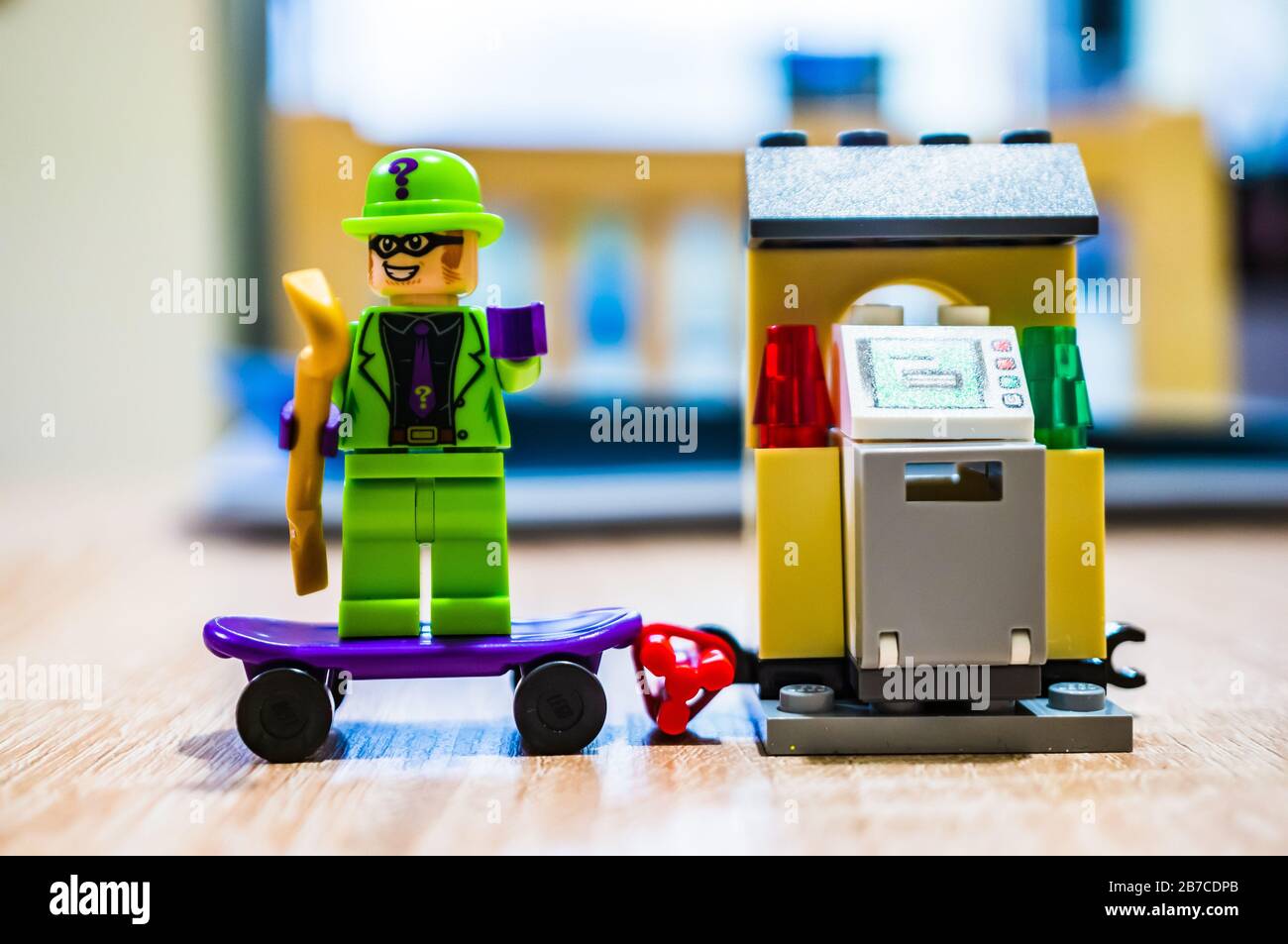 POSEN, POLEN - 29. Februar 2020: LEGO die Figur des Riddler Bösewichts, die auf einem Skateboard steht und mit einem Raub im Hintergrund des weichen Fokus beschäftigt ist. Figurine i. Stockfoto