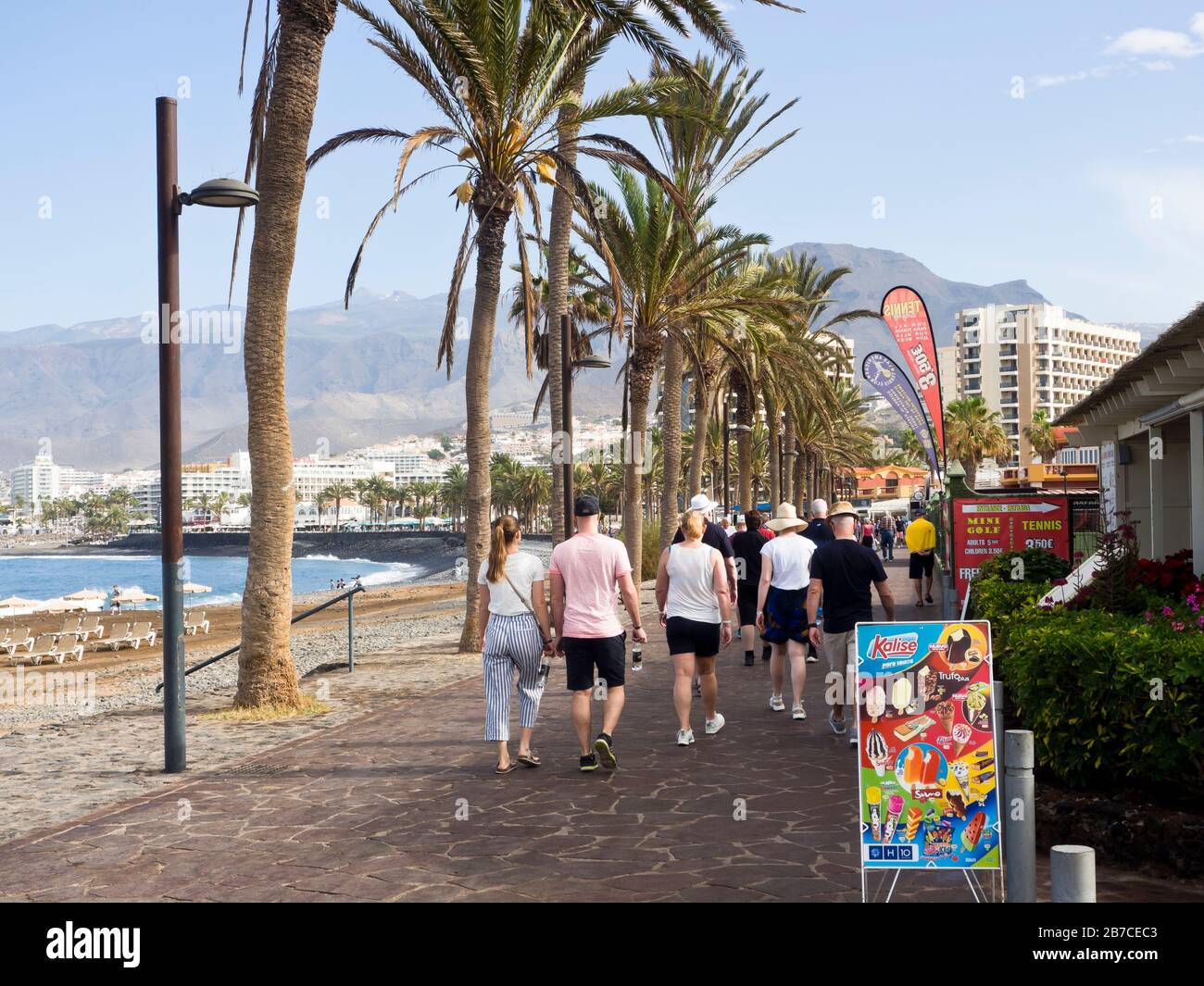 Eine morgendliche Promenade entlang der Küste in Playa de las Americas, auf der Insel Tena, auf den Kanarischen Inseln, Spanien, ein Hazy Teide in der Ferne Stockfoto