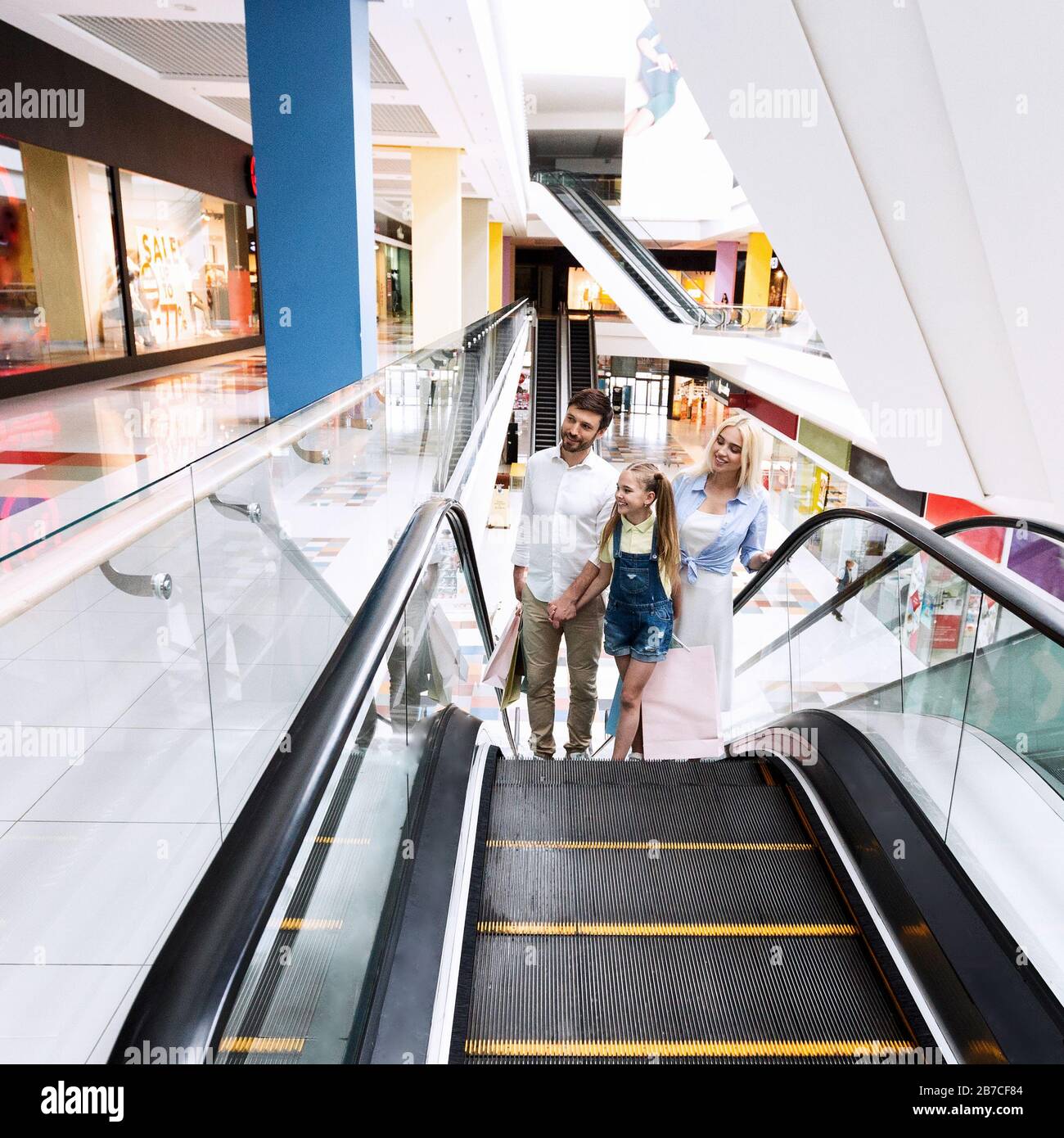 Familie Auf Dem Einkaufen, Die Sich Auf Der Escalator-Treppe In Hypermarket Bewegt Stockfoto