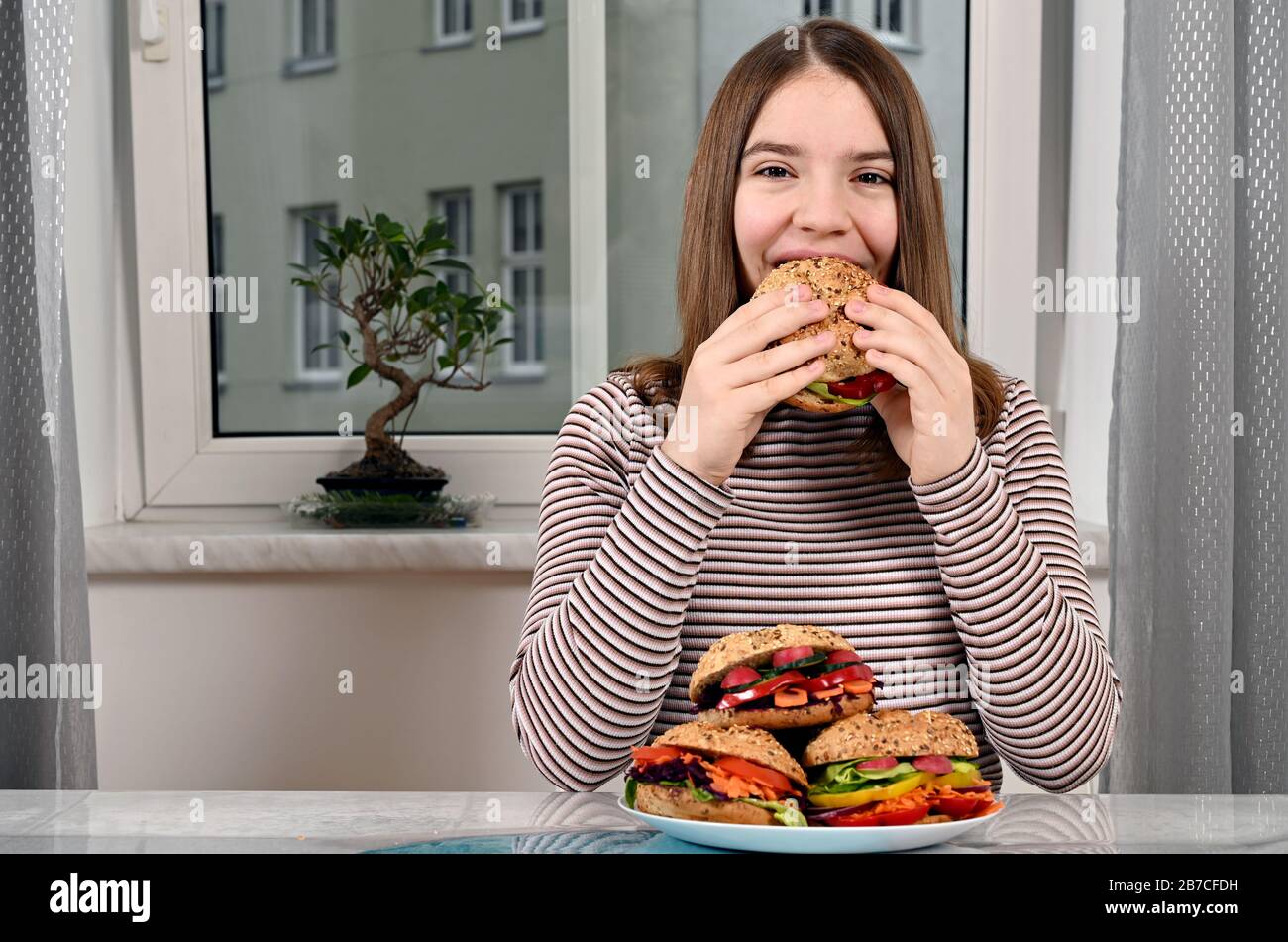 Hungriges Mädchen, das veganes Sandwich isst Stockfoto