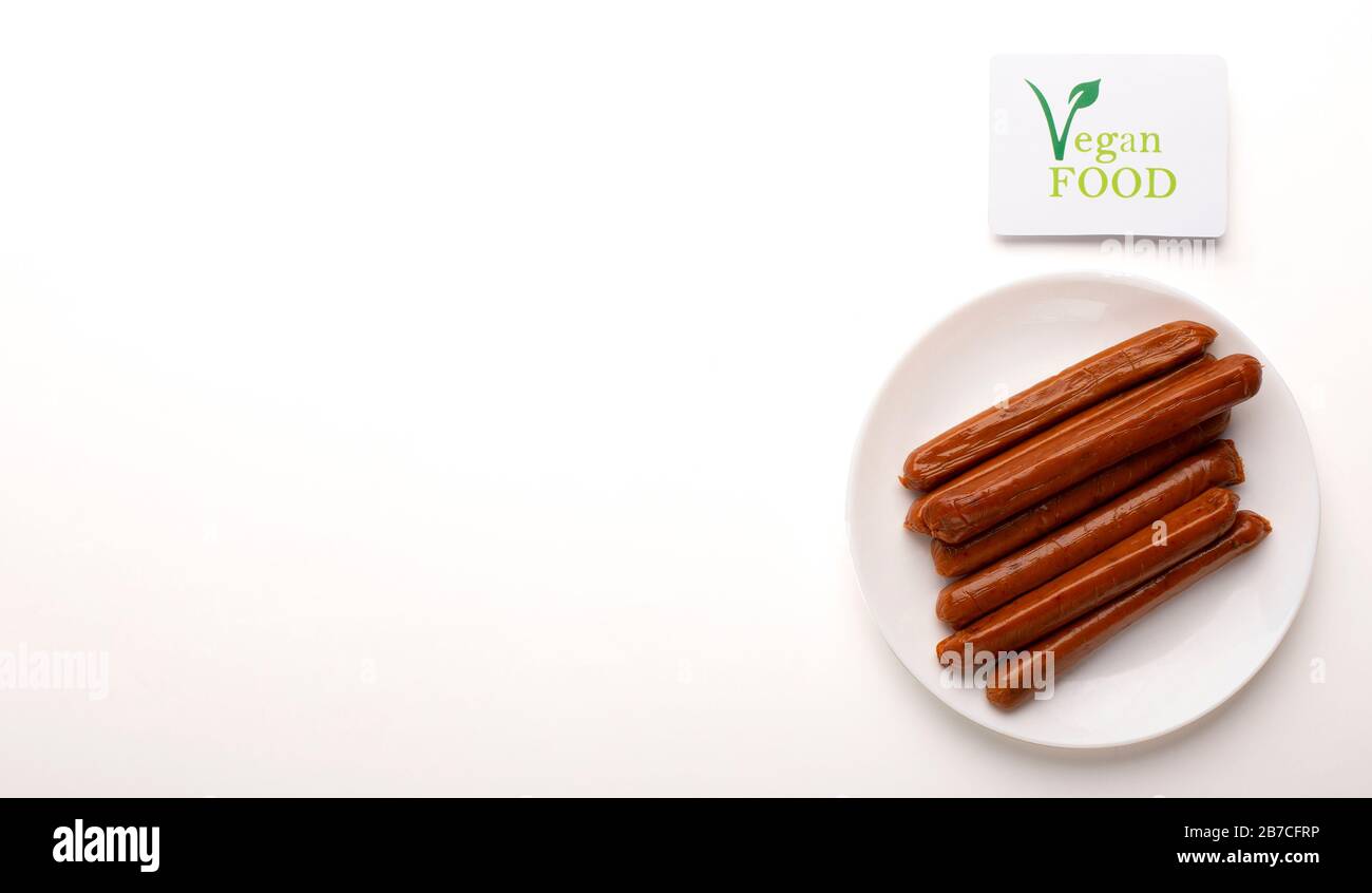 Fleischlose Würstchen auf dem Teller mit Logo vegane Speisen Stockfoto