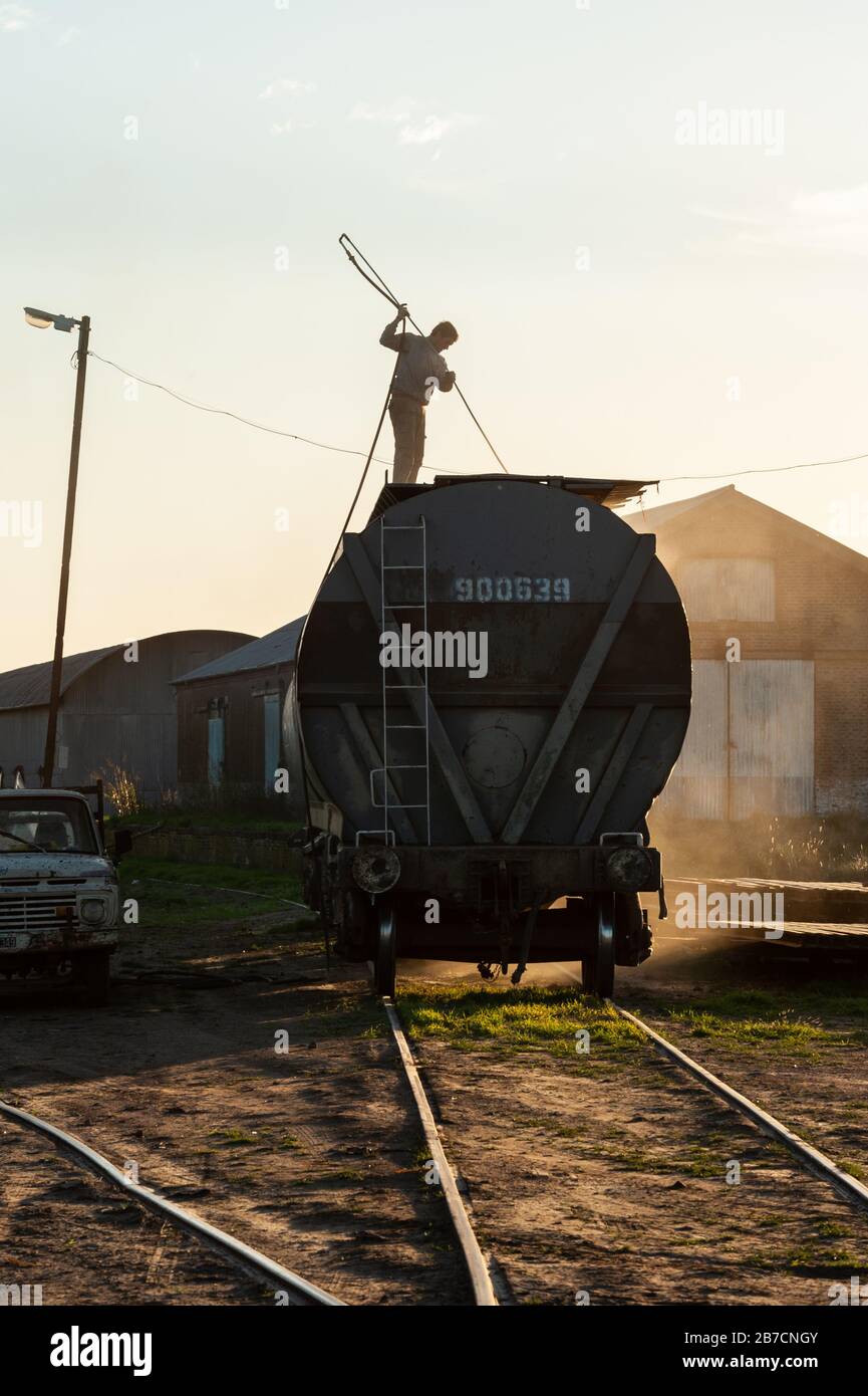 Buenos Aires, Argentinien - 05. Mai 2014: Ein Mann säubert einen Güterzugwagen mit Druckluft in der Provinz Buenos Aires. Stockfoto