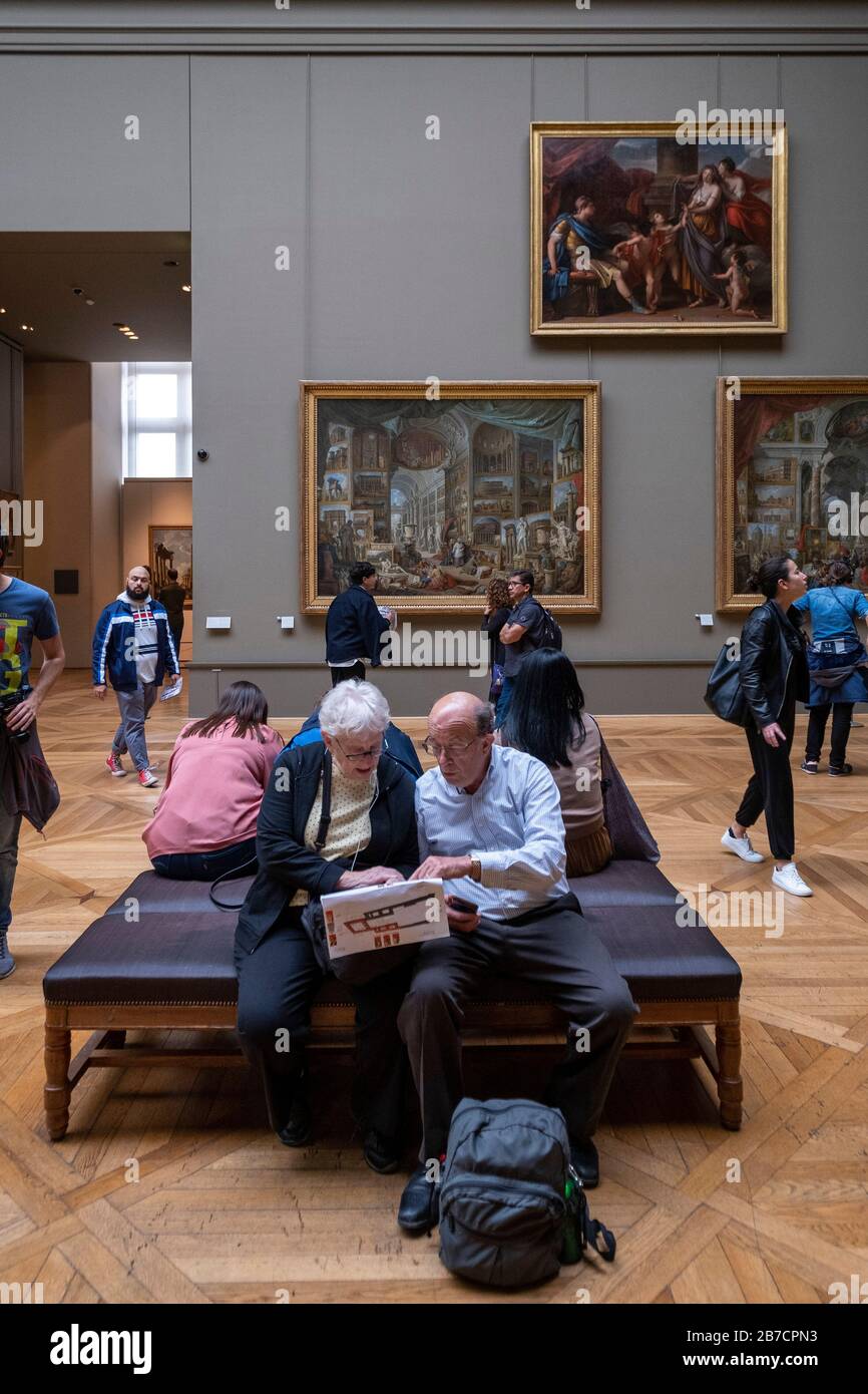 Ältere Touristen, die eine Karte des Louvre Museums in Paris, Frankreich, Europa betrachten Stockfoto