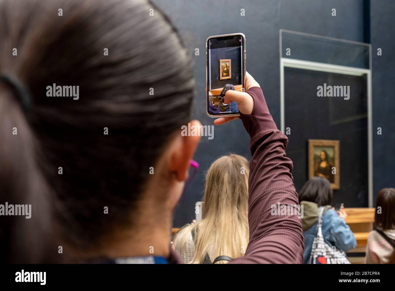 Tourist, die mit ihrem Smartphone Bilder des Mona-Lisa-Gemäldes der Künstlerin Leonardo da Vinci, Louvre Museum, Paris, Frankreich, Europa fotografiert Stockfoto