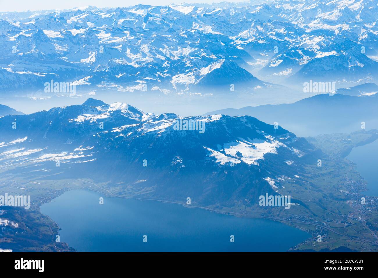 Einzigartiges alpines Luftpanorama. Blauer Planet Erde Höhenflug von einem Flugkabinenfenster aus, das über Zürich fliegt, aus dem Blick auf die Schweizer Alpen Stockfoto