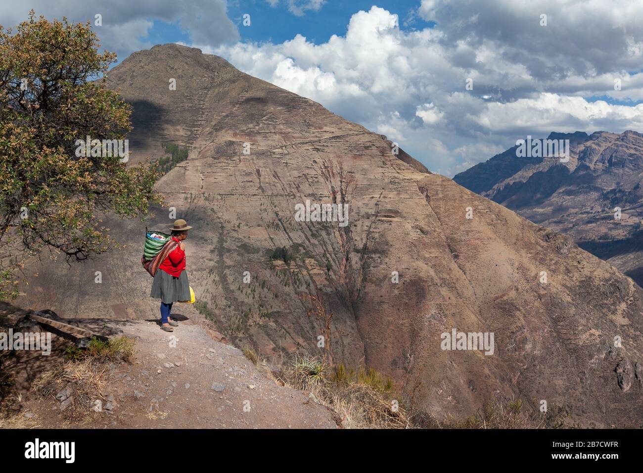 Heilig Tal, Peru: Quechua-Frau in traditioneller farbenfroher Kleidung mit Rucksack in peruanischen Anden Trockenzeit Stockfoto