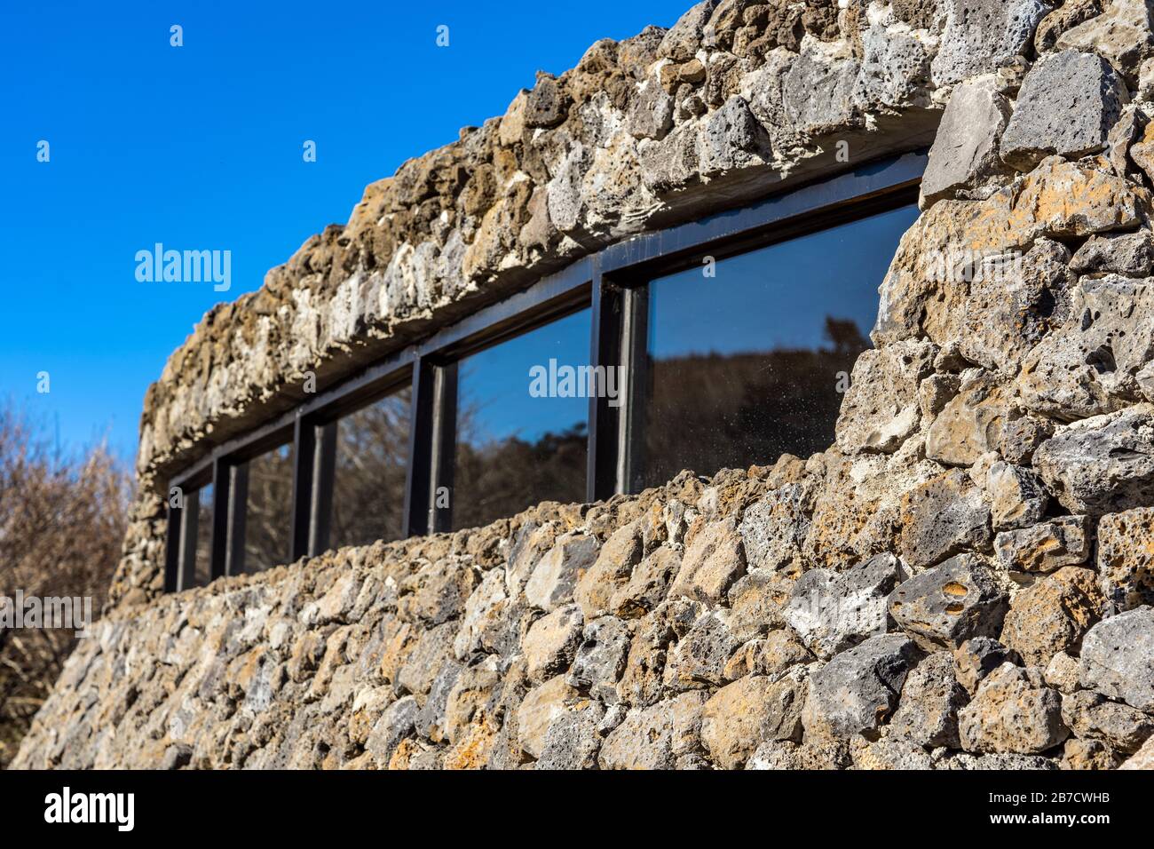 Geschlossen mit moderner öffentlicher Architektur. Gebogene schräge Wand aus Stein. The Rock Shed. Stockfoto
