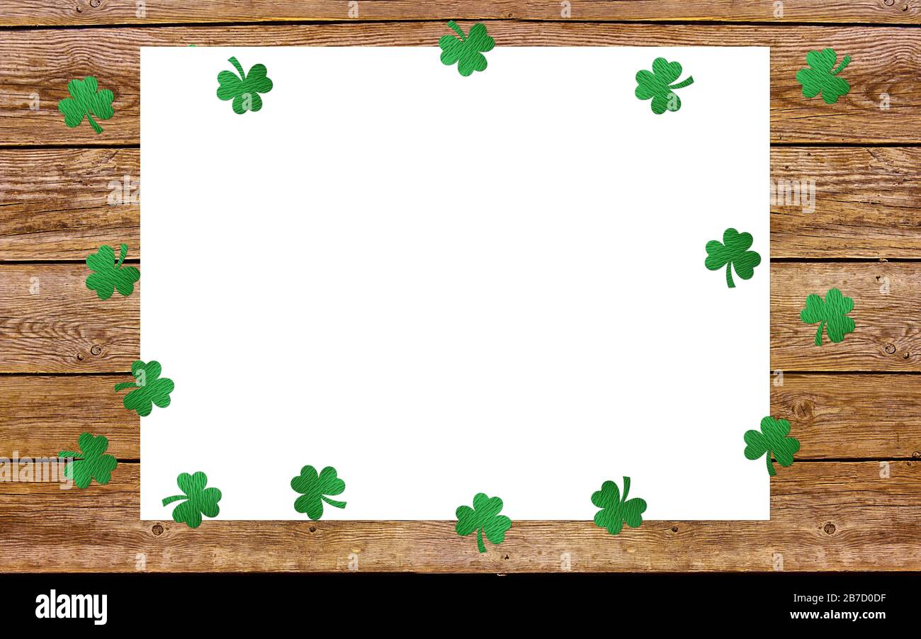 Auf dem alten Holzhintergrund blättert Papierklee. Lucky Shamrock, St. Patrick's Day Feriensymbol. Platz für Text, Draufsicht. Stockfoto