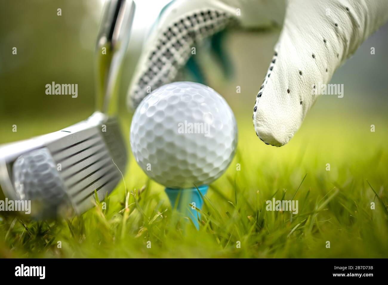 Hand in Hand platzieren Golfball auf T-Stück Stockfoto