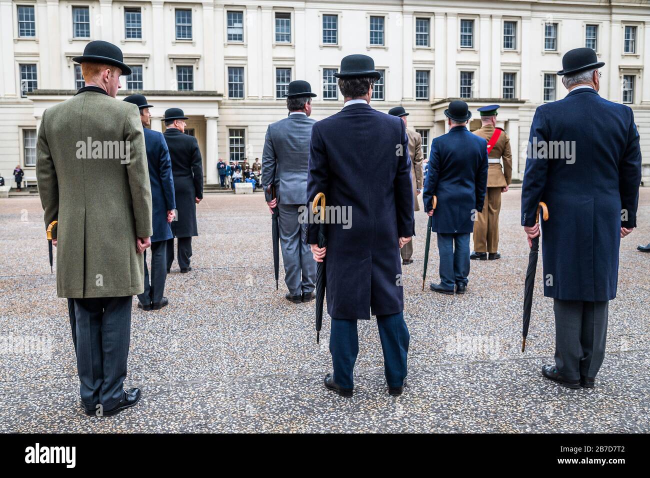 London, Großbritannien. März 2020. Pensionierte Offiziere parieren in Bowler-Hüten mit verfellten Regenschirmen - jährliche St Patricks' Day Parade der Irish Guards in Wellington Barracks, London. Traditionell wurden die Soldaten mit frischen Shamrocks ausgestellt - heute von Lady Carleton-Smith, Ehefrau des Generalstabschefs, General Sir Mark Carleton-Smith. Die Parade wurde von der Band of the Irish Guards geleitet und umfasste Mitglieder des 1st Battalion Irish Guards, D Coy London Irish Rifles, London Regiment und pensionierte Offiziere und Soldaten beider Regimenter. Credit: Guy Bell/Alamy Live News Stockfoto
