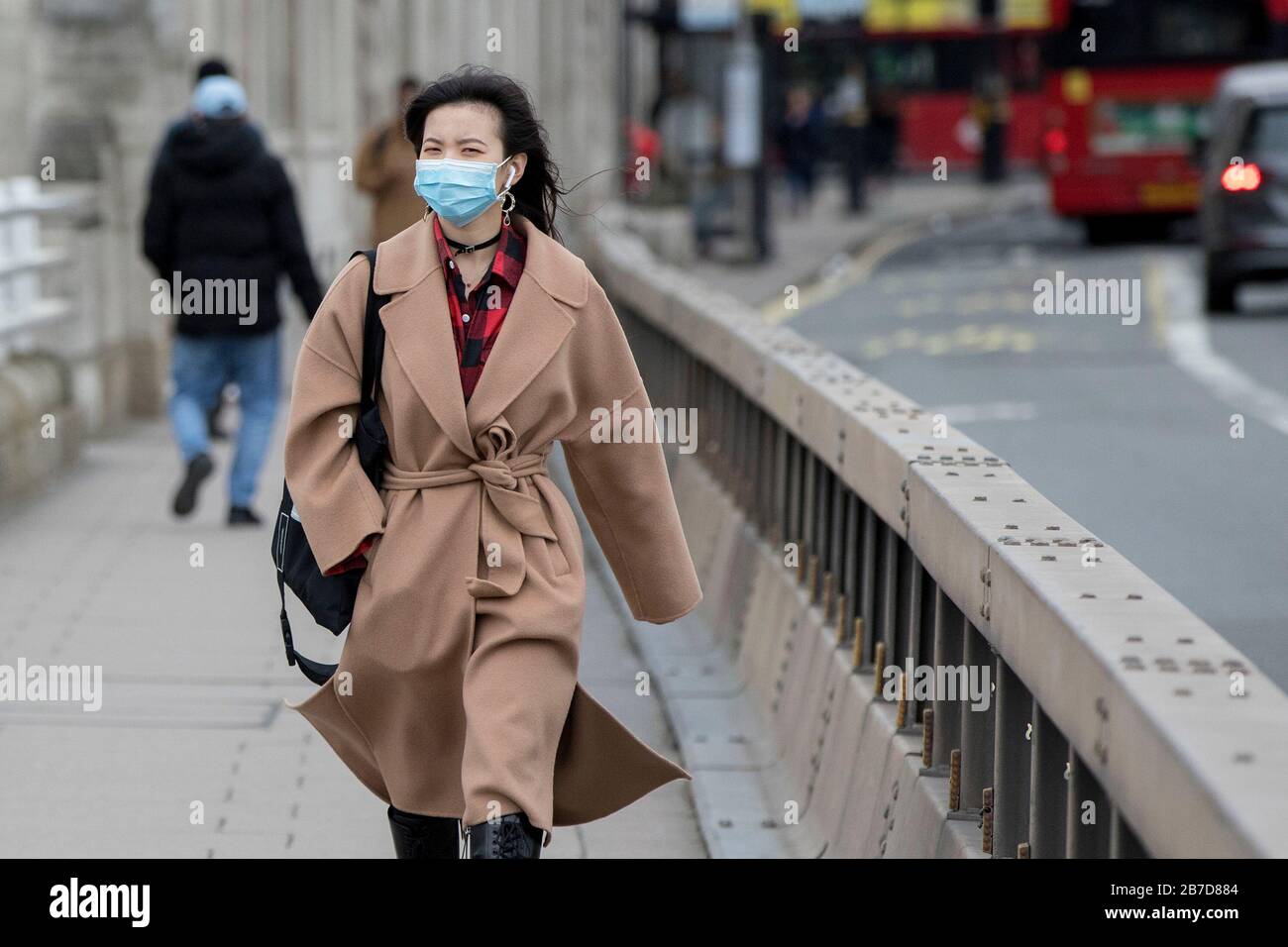 Eine Frau, die eine schützende Gesichtsmaske trägt, spaziert in London, wie Gesundheitsminister Matt Hancock sagte, dass die Minister noch keine Entscheidung darüber treffen müssen, ob Versammlungen von über 500 Menschen im Rest des Vereinigten Königreichs verboten werden sollen, nachdem Schottland sagte, dass es ab Montag Einschränkungen bringen würde. Stockfoto