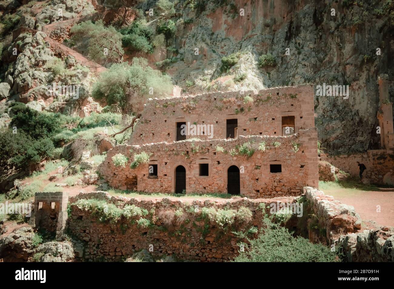 Blick auf die Ruinen der verlassenen Klosterkirche von Katholiko auf der sonnigen Insel Kretas. Schöne mediterrane Natur in Griechenland. Einzigartige Steinkonstruktion in Th Stockfoto