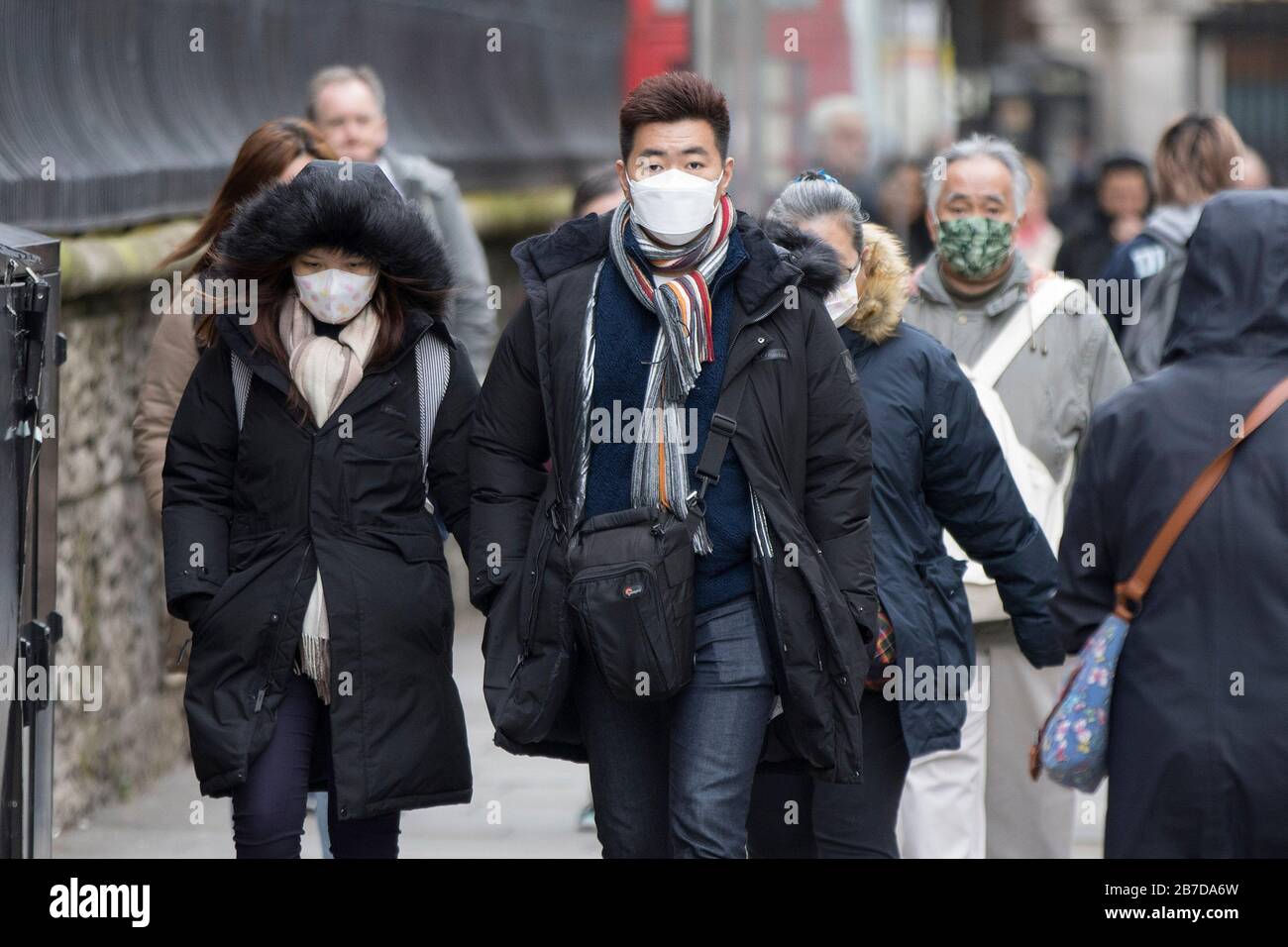 Menschen, die schützende Gesichtsmasken tragen, spazieren in London, wie Gesundheitsminister Matt Hancock sagte, dass die Minister noch keine Entscheidung darüber treffen müssen, ob Versammlungen von über 500 Menschen im Rest des Vereinigten Königreichs verboten werden sollen, nachdem Schottland sagte, dass es ab Montag Einschränkungen bringen würde. Stockfoto
