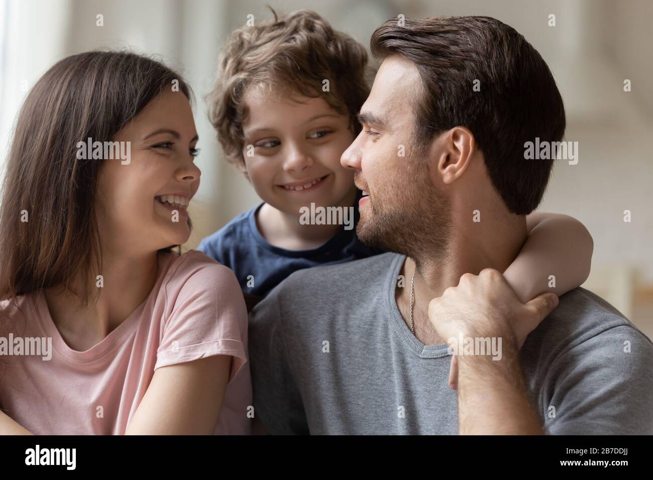 Glückliche Familie mit kleiner Kinderkudel, die Liebe zeigt Stockfoto