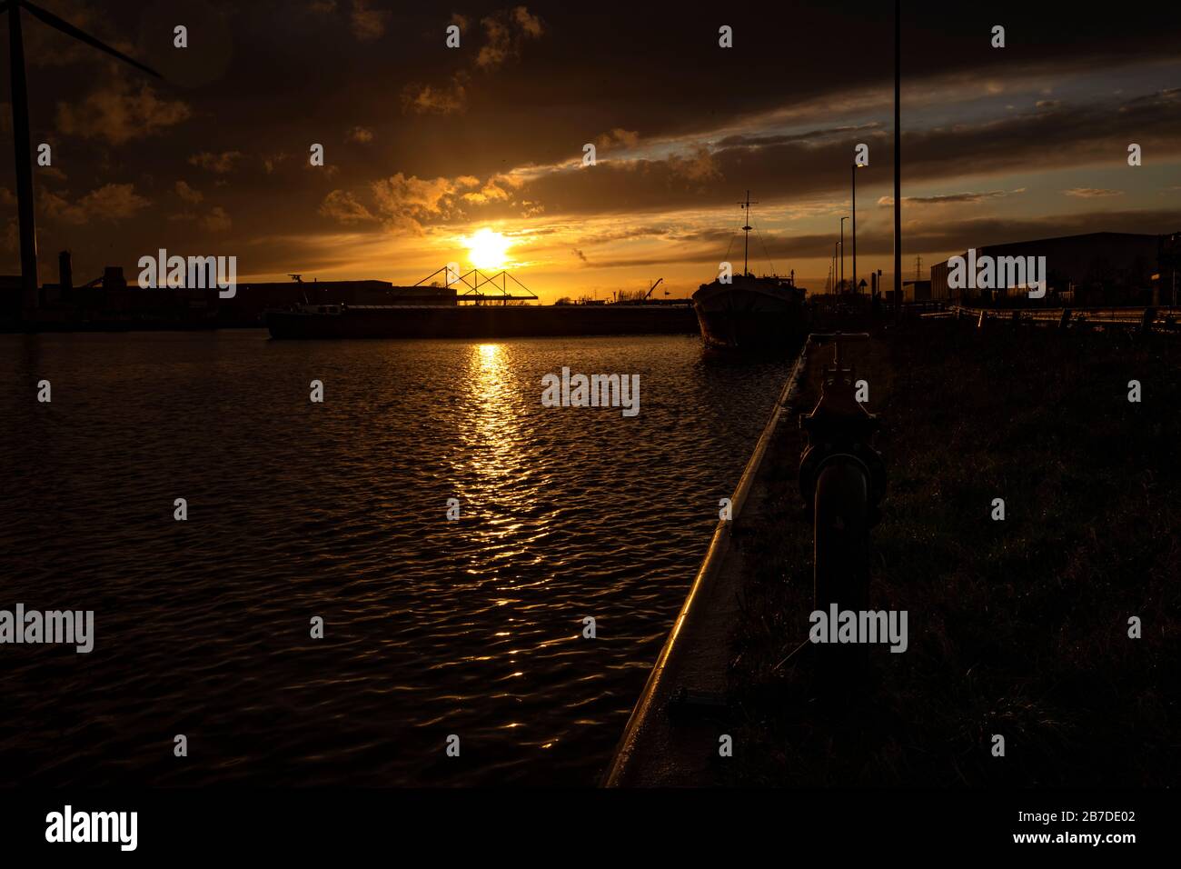 Boote auf dem Wasser bei Sonnenuntergang an einem bewölkten Tag Stockfoto