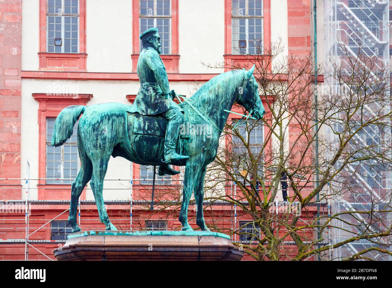 Bronzene Pferdereiter-Statue, die den Ludwig IV., Großfürst von Hessen mit dem Wohnpalast im Hintergrund darstellt. Darmstadt-Land. Stockfoto