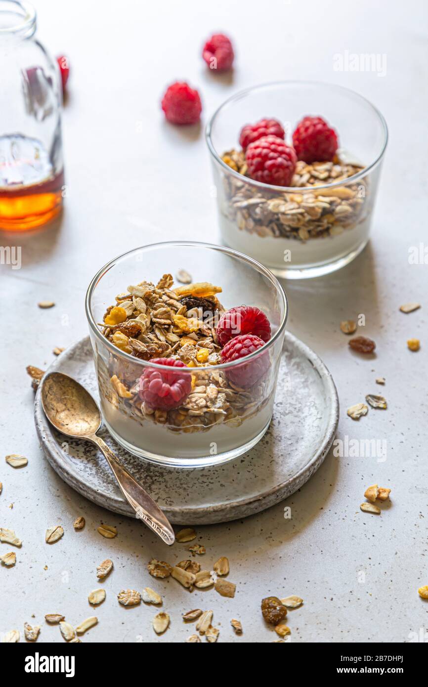 Gesundes Frühstück, Kokosjoghurt, serviert mit hausgemachtem Müsli und frischen Rasbeeren. Stockfoto