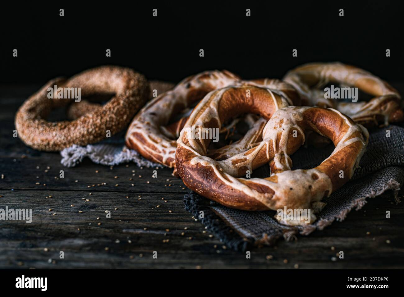 Deutsches Brot Pretzel und Bagel Frühstück auf einem Holztisch. Schwarzer Hintergrund Stockfoto