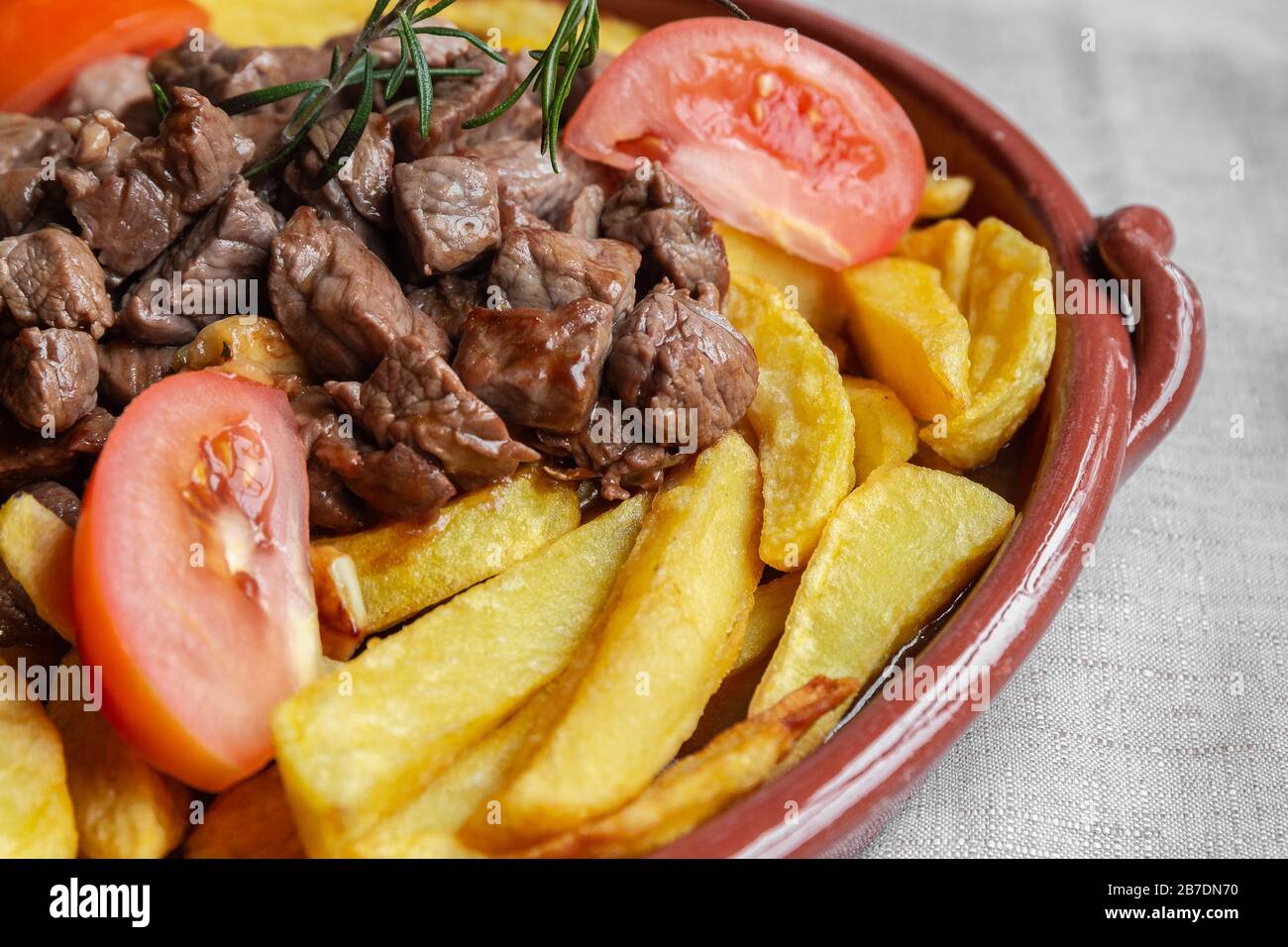 Traditionelles Gericht auf der Insel Madeira, "Picado" oder "Picadinho" genannt, mit Rind in kleine Würfel geschnitten, Pommes Frites in Scheiben geschnitten Tomaten und Knoblauch zubereitet. Stockfoto