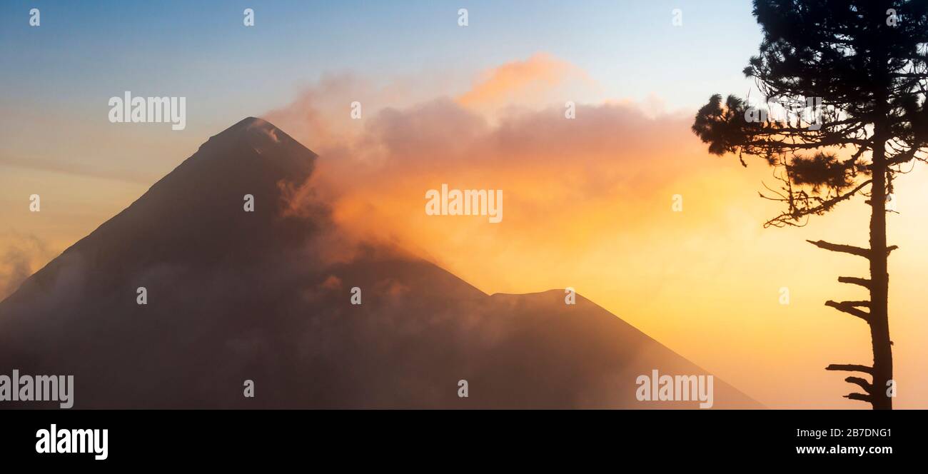 Vulkan Fuego (Volcan de Fuego) bei Sonnenuntergang mit Rauch und Wolken vom Vulkan Acatenango aus gesehen Stockfoto