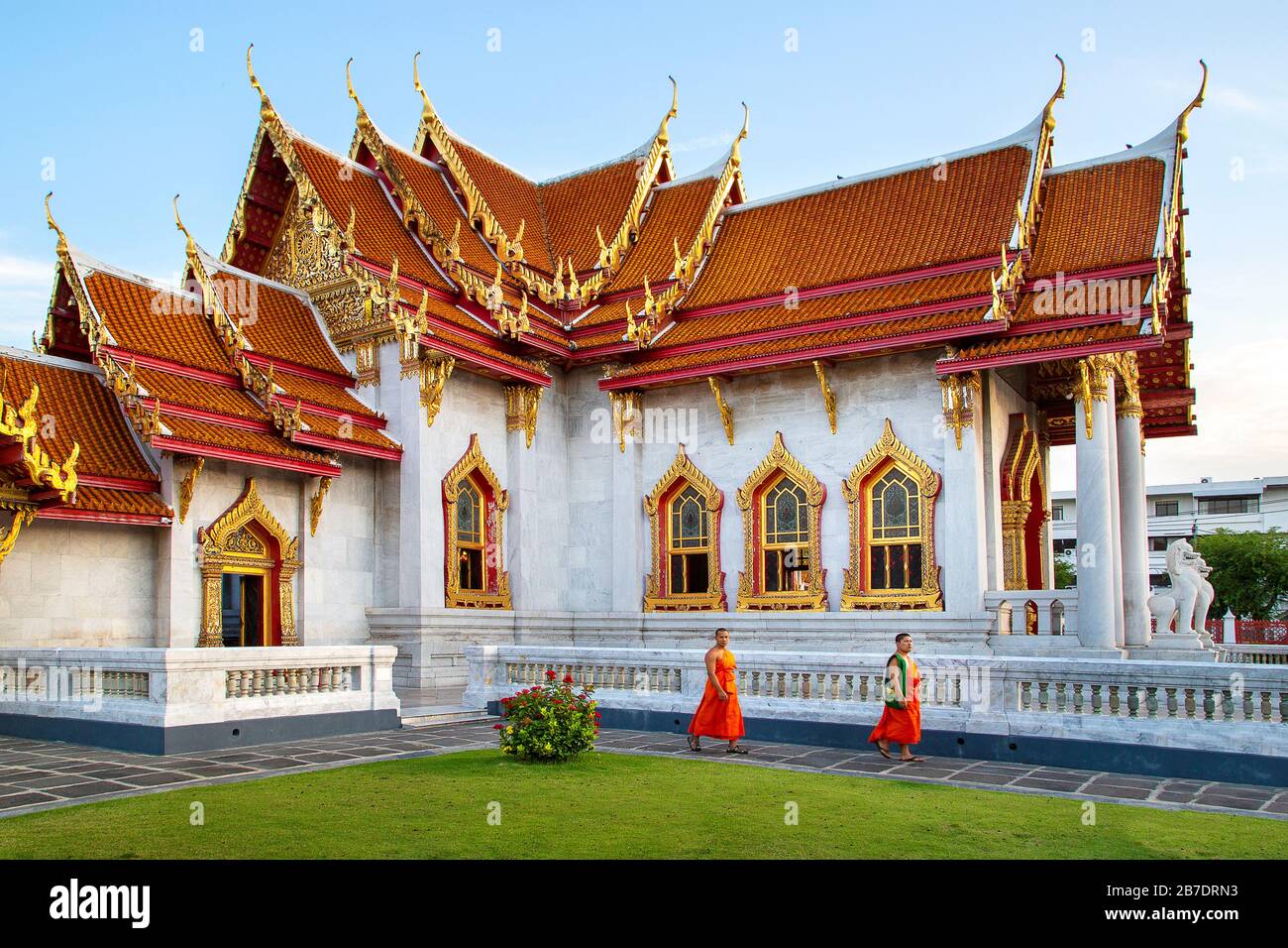Buddhistischer Marmortempel, auch Wat Benchamabopit Dusitvanaram genannt, mit Mönchen, die im Garten spazieren, Bangkok, Thailand. Stockfoto