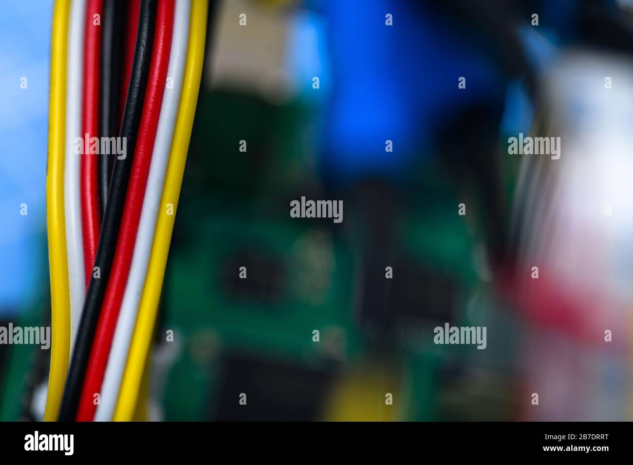 Schwarze, rote, weiße und gelbe Kabel auf einem Hintergrund, der nicht fokussiert ist. Stockfoto