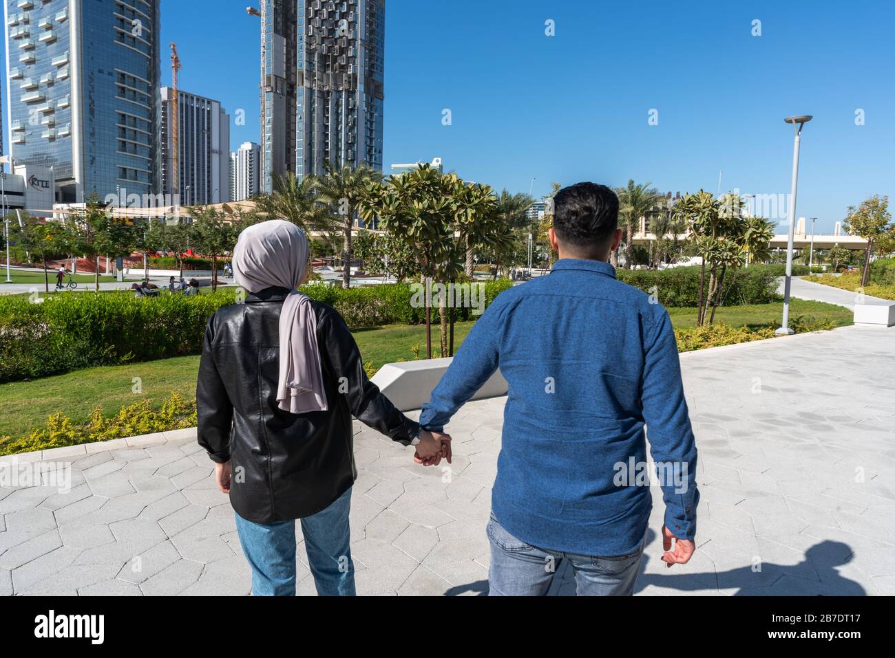 Muslimisches Paar liebt es, in einem Park draußen zu gehen und gleichzeitig die Hände zu halten Stockfoto