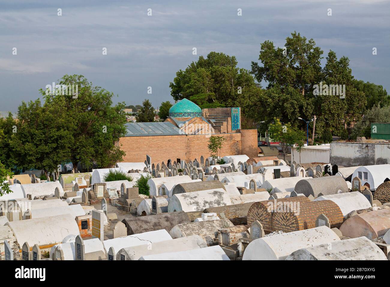 Alter Friedhof mit dem blauen Kuppelmausoleum von Madari Khan im Hintergrund, in Kokand, Usbekistan. Stockfoto