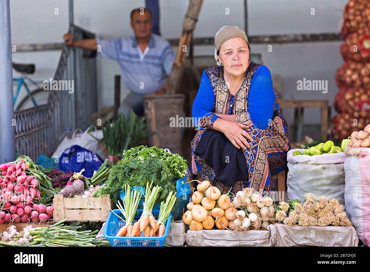 Usbekische Verkäuferin, die auf dem Markt Gemüse verkauft, in Margilan, Usbekistan. Stockfoto