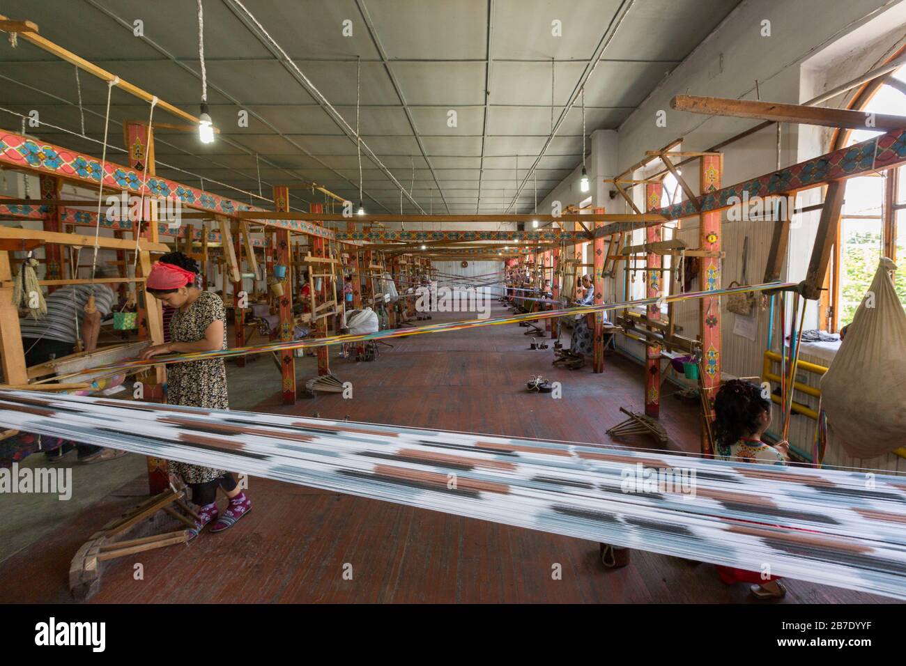 Frauen, die Seidenstoffe bearbeiten und wedeln, in der Seidenfabrik, Margilan, Usbekistan. Stockfoto