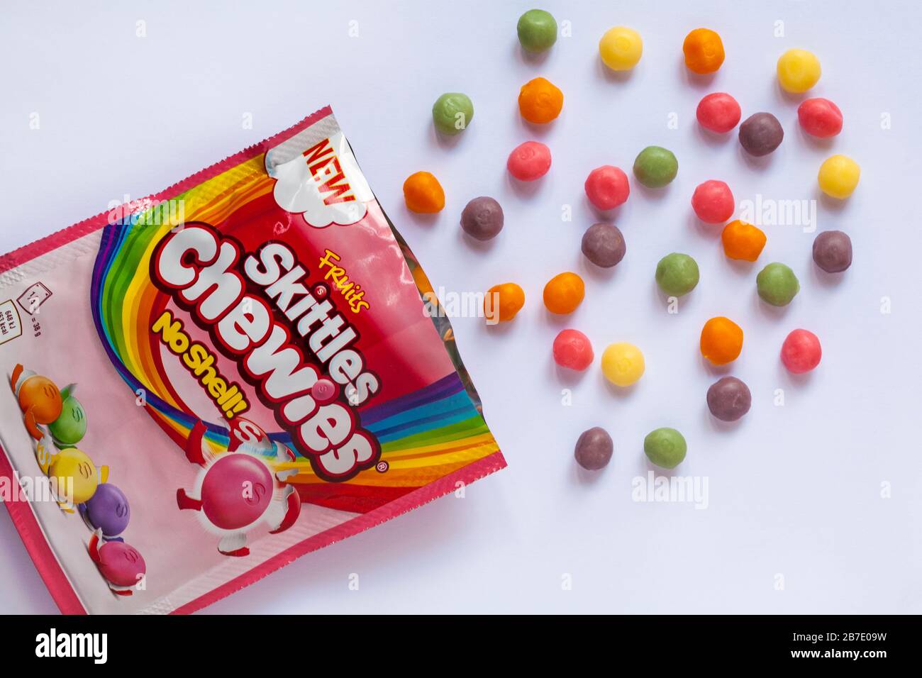 Obstpackung Skittles juckt Süßigkeiten keine Schale, die mit verschütteten,  verschütteten, auf weißem Hintergrund aufgesetzten Inhalten geöffnet wird -  neue weichere Textur - Süßigkeiten Stockfotografie - Alamy