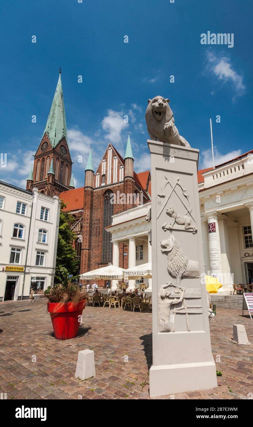 Löwenstatue von Peter Lenk am Marktplatz mit Löwendenkmal und Dom dahinter in Schwerin in Mecklenburg-Vorpommern Stockfoto