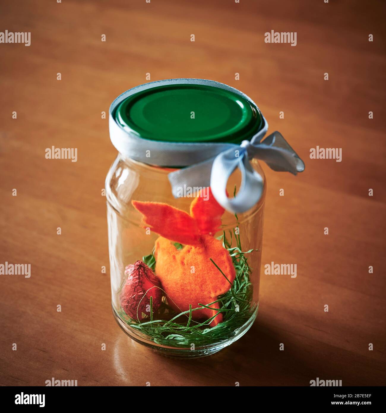 In einem verschraubten Gefäß sehen Sie ein Osterbrötchen und eine Osterdekoration als Symbol für Ostern in Quarantäne. Stockfoto