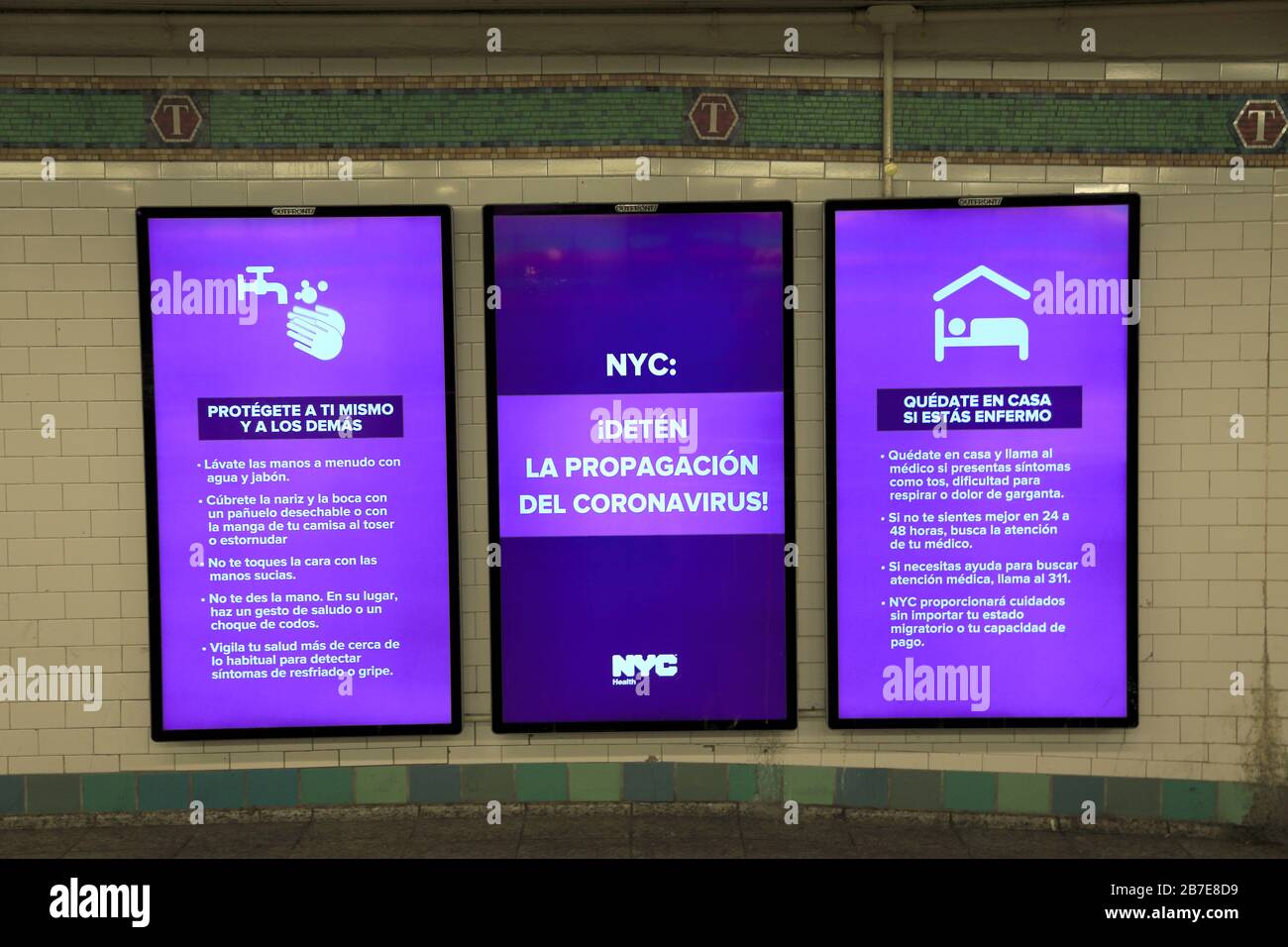 Digitale MTA-Schilder zeigen Informationen in spanischer Sprache an, wie man eine Verbreitung von Coronavirus, Time Squares Subway Station, New York City, 15. März, verhindern kann. Stockfoto